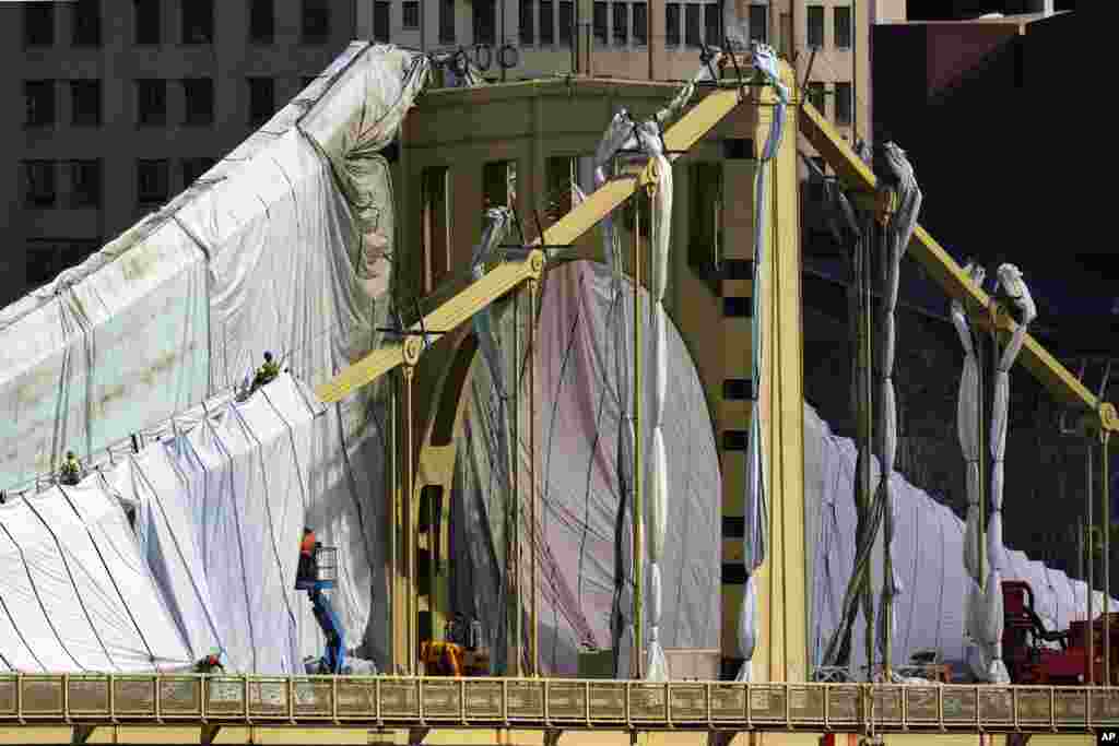 Workers prepare the Roberto Clemente bridge for refurbishing in downtown Pittsburgh, Pennsylvania, April 12, 2022.