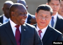 DOSSIER – Le président chinois Xi Jinping marche avec le président sud-africain Cyril Ramaphosa avant leur rencontre à Pretoria, Afrique du Sud, le 24 juillet 2018.