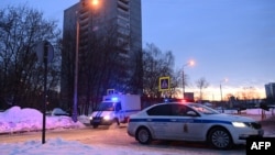 FILE - A police van with escort vehicle is seen driving down a street in Moscow, Russia, Feb. 20, 2021. 