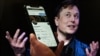 Dans cette photo d'illustration, un écran de téléphone affiche le compte Twitter d'Elon Musk avec une photo de lui en arrière-plan, le 14 avril 2022, à Washington, DC.