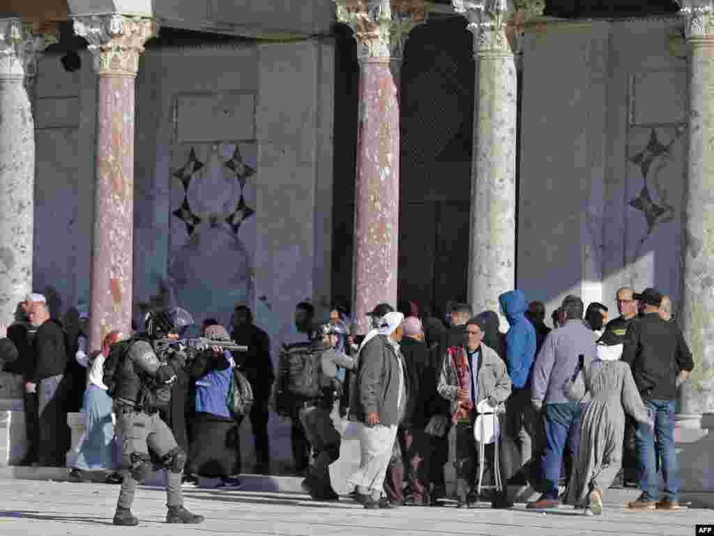 Palestinians are kept at bay by Israeli police during clashes at Jerusalem&#39;s Al-Aqsa mosque compound.