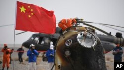 In this photo released by China's Xinhua News Agency, the return capsule of the Shenzhou-13 manned space mission is seen after landing at the Dongfeng landing site in northern China's Inner Mongolia Autonomous Region, April 16, 2022.