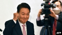 FILE - South Korea's president-elect Yoon Suk-yeol gestures during a ceremony disbanding the presidential election camp at the National Assembly Library in Seoul on March 10, 2022. (Photo by SONG Kyung-Seok / POOL / AFP)