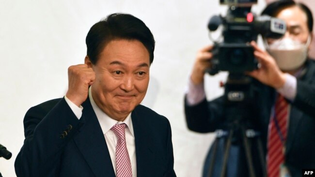 FILE - South Korea's president-elect Yoon Suk-yeol gestures during a ceremony disbanding the presidential election camp at the National Assembly Library in Seoul on March 10, 2022. (Photo by SONG Kyung-Seok / POOL / AFP)