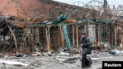 A man walks past a destroyed building in the southern port city of Mariupol, Ukraine, during Russia's invasion of Ukraine, April 14, 2022.