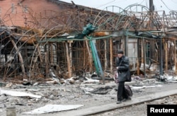 A man walks past a destroyed building in the southern port city of Mariupol, Ukraine, during Russia's invasion of Ukraine, April 14, 2022. (REUTERS/Alexander Ermochenko)