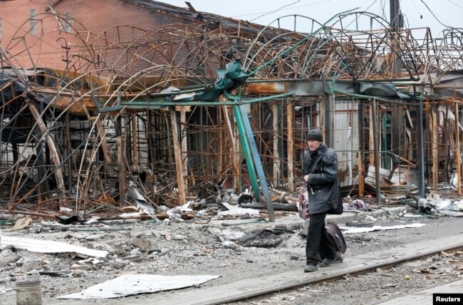 A man walks past a destroyed building in the southern port city of Mariupol, Ukraine, during Russia's invasion of Ukraine, April 14, 2022. (REUTERS/Alexander Ermochenko)