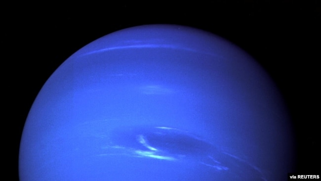 The "Great Dark Spot", a storm in the atmosphere and the bright, light-blue smudge of clouds that accompanies the storm is seen on the planet Neptune, taken by the NASA spacecraft Voyager 2 less than five days before its closest approach of the planet on 