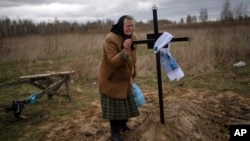 Nadiya Trubchaninova, 70, cries at the grave of her son Vadym, 48, who was killed by Russian soldiers, March 30, 2022, in Bucha, during his funeral in the cemetery of Mykulychi, on the outskirts of Kyiv, Ukraine, April 16, 2022. 