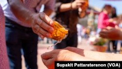 People splash water on each other but bathe the Buddha Praying for blessings for good fortune in life during Songkran and Thai New Year Celebration event at Wat Thai (Temple) Los Angeles in North Hollywood, CA