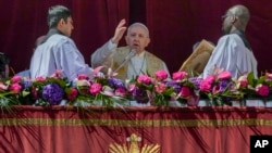 Pope Francis delivers the traditional 'Urbi et Orbi' (To the city and to the world) blessing at the end of the Catholic Easter Sunday Mass in St. Peter's Square at the Vatican, April 17, 2022.
