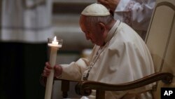 Pope Francis holds a Paschal candle as he attends an Easter vigil ceremony at St. Peter's Basilica at the Vatican, April 16, 2022.