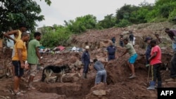 Family members help the South African Police Services (SAPS) Search and Rescue Unit clear debris during search efforts to locate 10 people who are unaccounted for from area of KwaNdengezi township outside Durban, April 15, 2022.