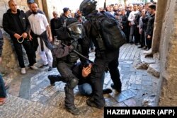 Pasukan keamanan Israel melumpuhkan seorang pria Palestina di pintu masuk kompleks masjid al-Aqsa ketika orang lain dilarang masuk, pada 15 April 2022. (Foto: AFP)