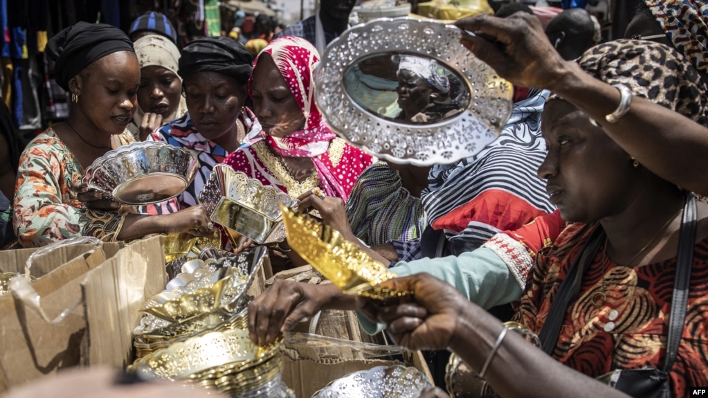 Des femmes achètent des bols et des assiettes sur un marché du centre historique de Rufisque, le 3 avril 2022, le premier jour du Ramadan.