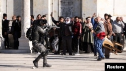 Seorang anggota pasukan keamanan Israel saat bentrokan dengan pengunjuk rasa Palestina di kompleks Masjid Al-Aqsa, yang dikenal oleh umat Islam sebagai Tempat Suci dan bagi orang Yahudi sebagai Temple Mount, di Kota Tua Yerusalem, 15 April 2022. (Foto: REUTERS/ Ammar Awad)