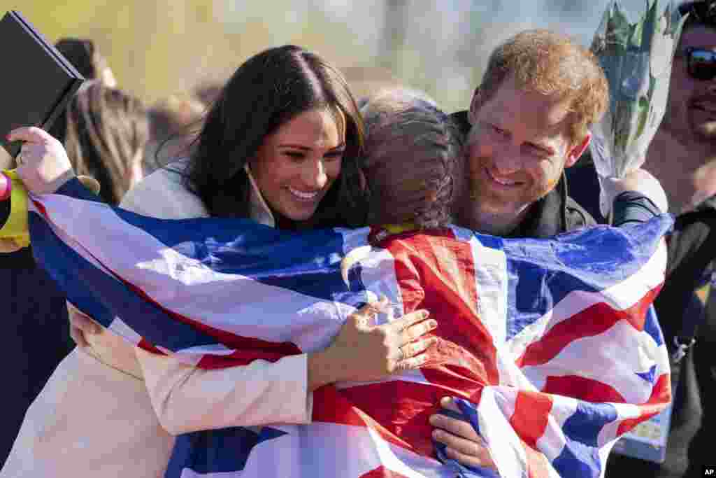 Prince Harry and Meghan Markle, Duke and Duchess of Sussex, hug Lisa Johnston, a former army medic and amputee, who celebrates with her medal at the Invictus Games venue in The Hague, Netherlands.