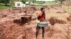 A man collects water near what remains of his home that collapsed while he was sleeping due to flooding in Mzinyathi near Durban, South Africa, April 17, 2022.