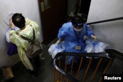 Volunteers hold anti-epidemic bags as they deliver them to residents during the COVID-19 pandemic, in Hong Kong, April 3, 2022.