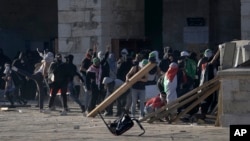 Palestinians clash with Israeli security forces at the Al Aqsa Mosque compound in Jerusalem's Old City Friday, April 15, 2022.