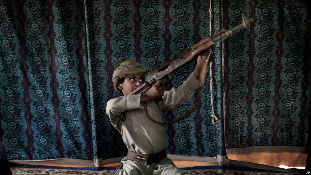 Kahlan, umwana w'imyaka 12 yahoze ari umwana wo mu ntambara mu barobeli b'abahutiariko yerekana uko barasisha inkoho i Marib, muri Yemeni, kw'itariki ya 27/07/2018.