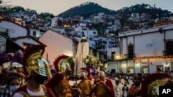 Imagen de Jesús Cautivo es escoltada por feligreses vestidos como soldados romanos durante una procesión de Semana Santa en Taxco, México, el jueves 14 de abril de 2022. (Foto Eduardo Verdugo / AP)