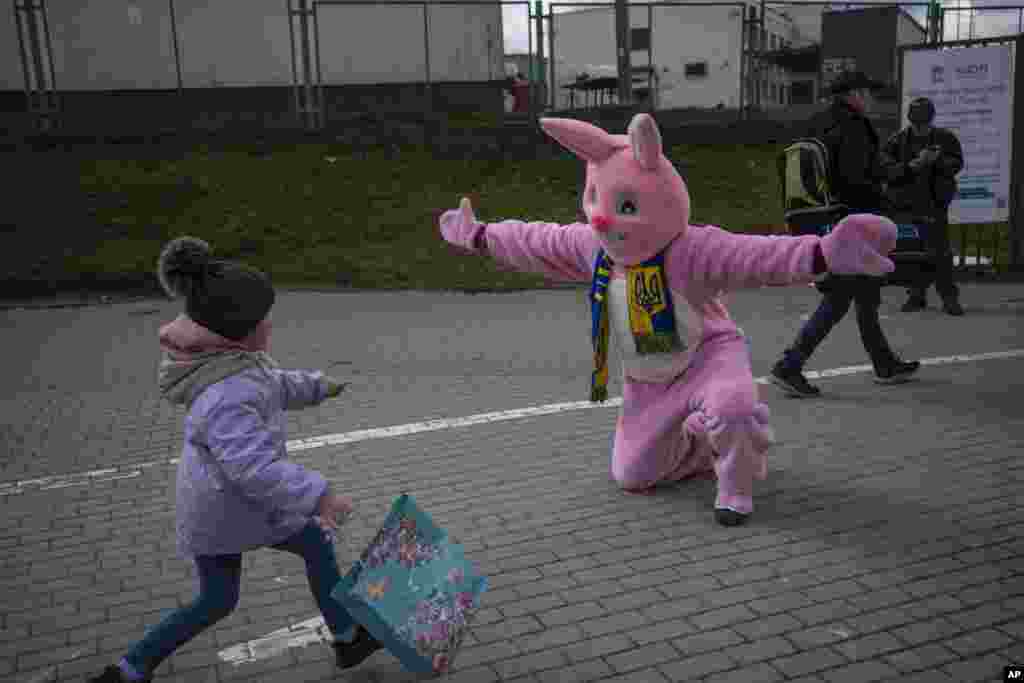 Performer Ben Dusing from Fort Mitchell, Kentucky, U.S., wears an Easter rabbit costume as he prepares to embrace Lilia at the Medyka border crossing in Poland.