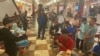 Miembros de organizaciones humanitarias reciben a migrantes trasladados de Texas a Washington DC en la zona de cafetería de Union Station, la mayoría provienen de Venezuela y Nicaragua y han sido aceptados para presentar peticiones de asilo. (Foto Divalizeth Murillo / VOA) 