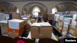 FILE - Members of the Ukrainian orthodox church community pray during their Sunday service in a church also temporarily used to store humanitarian aid ready to be transported to Ukraine, amid Russia's invasion of Ukraine, in Berlin, Germany, April 10, 2022.