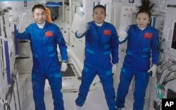 FILE - This photo released by Xinhua News Agency on Oct. 16, 2021, shows three Chinese astronauts, from left, Ye Guangfu, Zhai Zhigang and Wang Yaping.