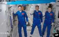 DOSSIER - Sur cette photo publiée par l'agence de presse Xinhua le 16 octobre 2021, montre trois astronautes chinois, de gauche à droite, Ye Guangfu, Zhai Zhigang et Wang Yaping.