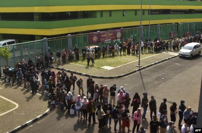 Warga antre untuk suntik booster Astrazaneca COVID-19 di Bekasi, Jawa Barat, 29 Maret 2022. (REZAS/AFP)