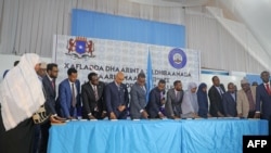 Newly sworn-in legislators take the oath during a swearing-in ceremony in Mogadishu's heavily protected airport, April 14, 2022.