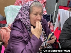 FILE - A Ukrainian refugee traveling with her daughters and granddaughters sits outside the San Ysidro port of entry in Tijuana, Mexico, on April 5, 2022, as she makes her way to another daughter already living in the U.S.