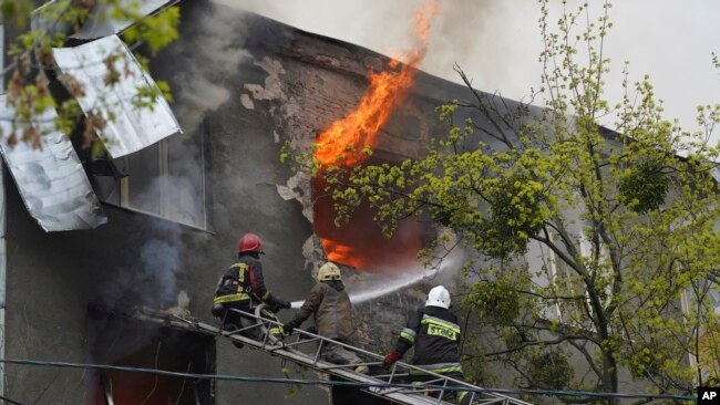 Los bomberos trabajan para extinguir el fuego en un edificio de apartamentos después de un ataque ruso en Kharkiv, Ucrania, el 17 de abril de 2022.