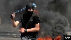 یک فلسطینی در حال پرتاب سنگ در محوطه مسجد الاقصی. ۱۵ آوریل ٢٠٢٢