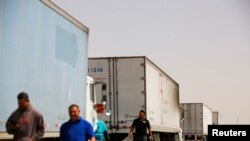 FILE: Truckers wait near their trailers near the Jeronimo-Santa Teresa International Bridge connecting the city of Ciudad Juarez to Santa Teresa, Nuevo Mexico, 4.12.2022