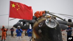 FILE - In this photo from China's Xinhua News Agency, the return capsule of the Shenzhou-13 space mission is seen after landing at the Dongfeng site in China, April 16, 2022. 