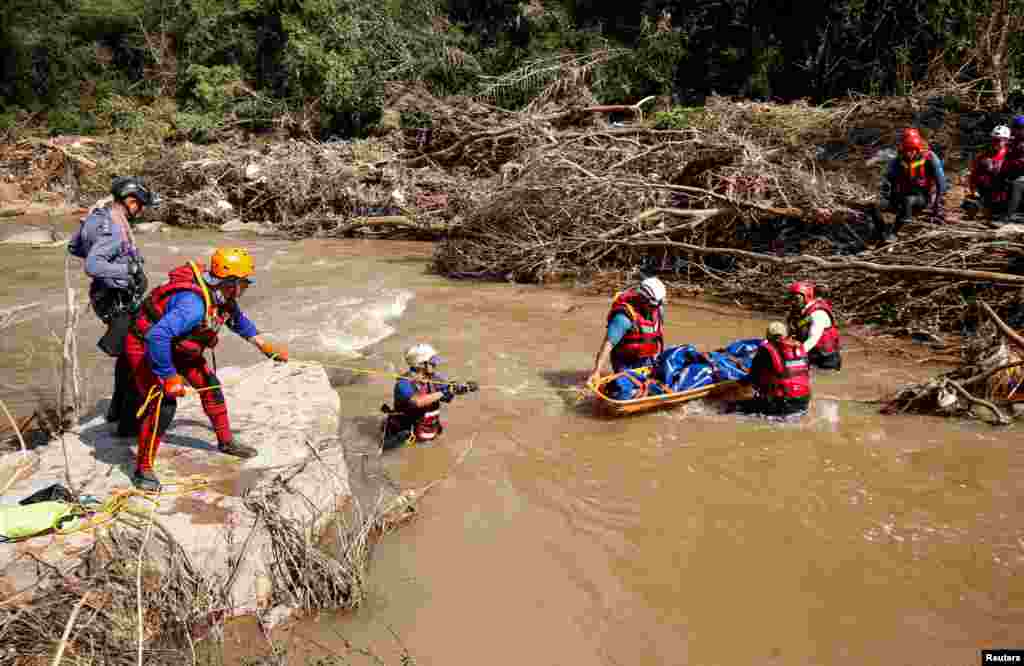 A search and rescue team prepares to airlift a body from the Mzinyathi River after heavy rains caused flooding near Durban, South Africa.