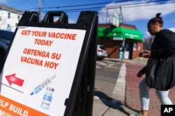 FILE - A sign promoting available COVID-19 vaccines stands outside a vaccination clinic in Providence, R.I., March 3, 2022.