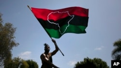 FILE - A man waves a Pan-African flag on horseback during a Juneteenth celebration in Los Angeles, June 19, 2020.