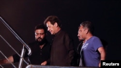 Former Pakistani Prime Minister Imran Khan, center, arrives to address the first public gathering after he was ousted from the parliament, in Peshawar, Pakistan April 13, 2022.