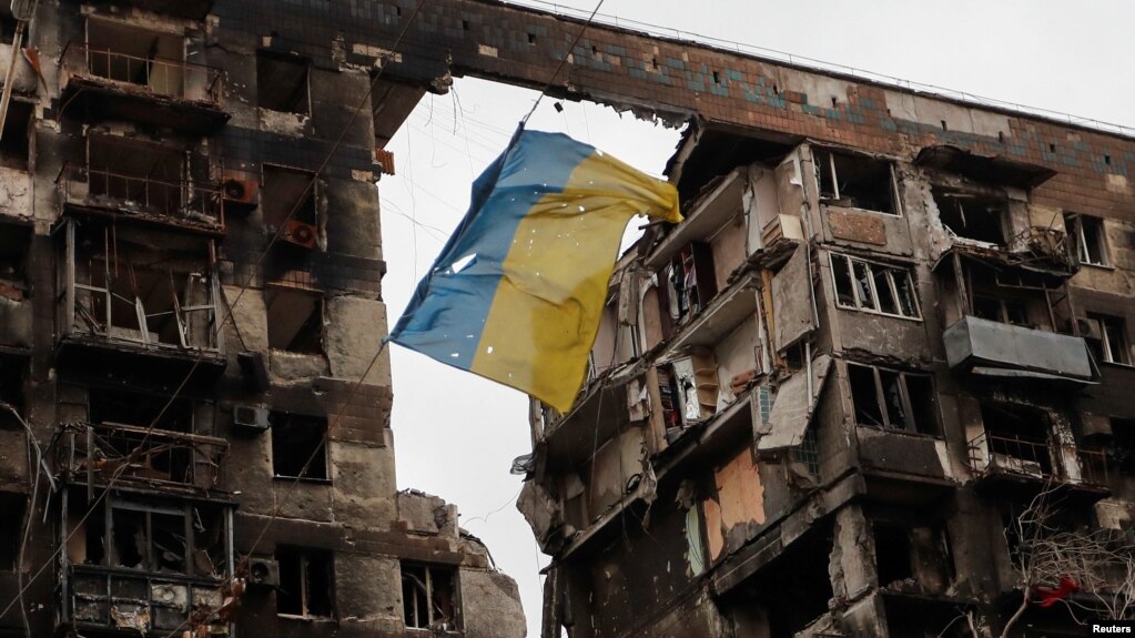 A view shows a torn flag of Ukraine hung on a wire in front an apartment building destroyed during Ukraine-Russia conflict in the southern port city of Mariupol, Ukraine April 14, 2022. (REUTERS/Alexander Ermochenko)