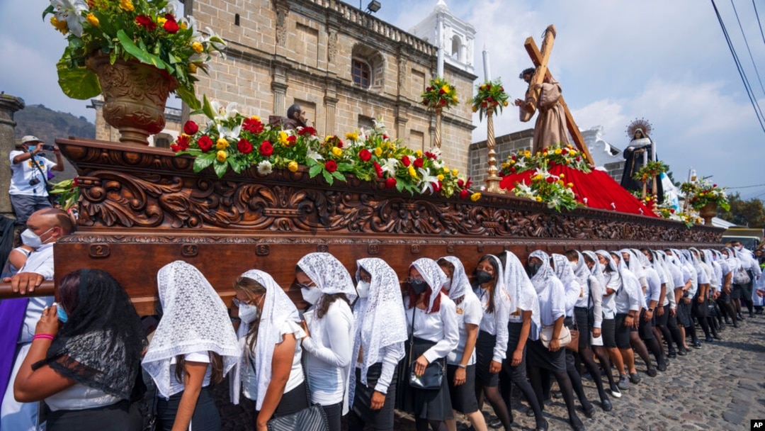 Un grupo de mujeres porta el paso de Jesucristo Crucificado en una procesión del Jueves Santo en la Antigua Guatemala, el 14 de abril de 2022.