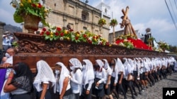 Un grupo de mujeres porta el paso de Jesucristo Crucificado en una procesión del Jueves Santo en la Antigua Guatemala, el 14 de abril de 2022.