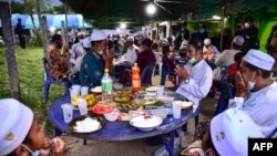 FILE - People praying before they break fast during an event in Narathiwat's Rangae district, Apr. 14, 2022, as Muslim worldwide observe the holy month of Ramadan. 
