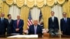 El presidente de EE.UU., Donald Trump, rodeado por varios de sus asesores en la Oficina Oval de la Casa Blanca en el momento de anunciar el acuerdo.
