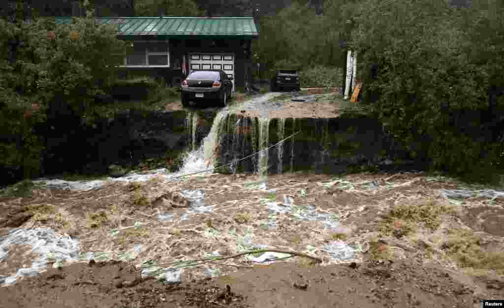 A home and car are stranded after a flash flood in Coal Creek destroyed the bridge near Golden, Colorado, Sept. 12, 2013.&nbsp;