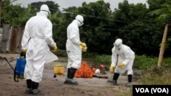 Le personnel de santé s'active à désinfecter les alentours d'une résidence où des personnes infectées d'Ebola habitaient.