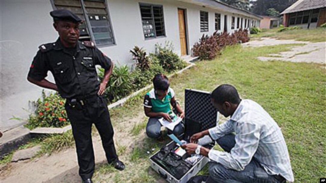 A police officer provides security as Electoral Officials check voter registration material and election equipment at a distribution center in Lagos, Nigeria, 15 Jan, 2011